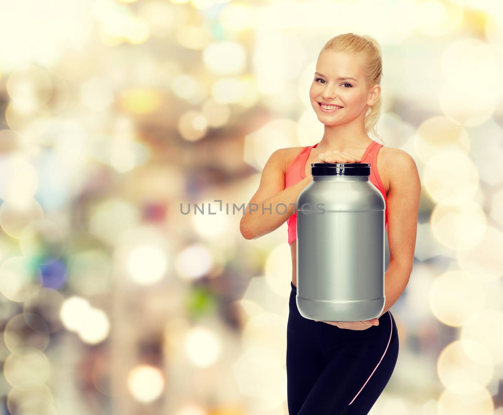 smiling sporty woman with jar of protein by dolgachov