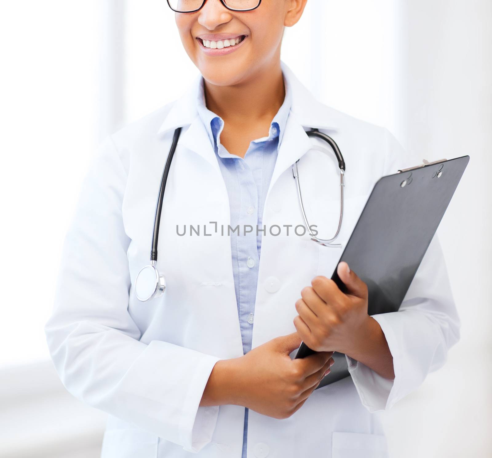 healthcare and medical concept - smiling african female doctor in hospital