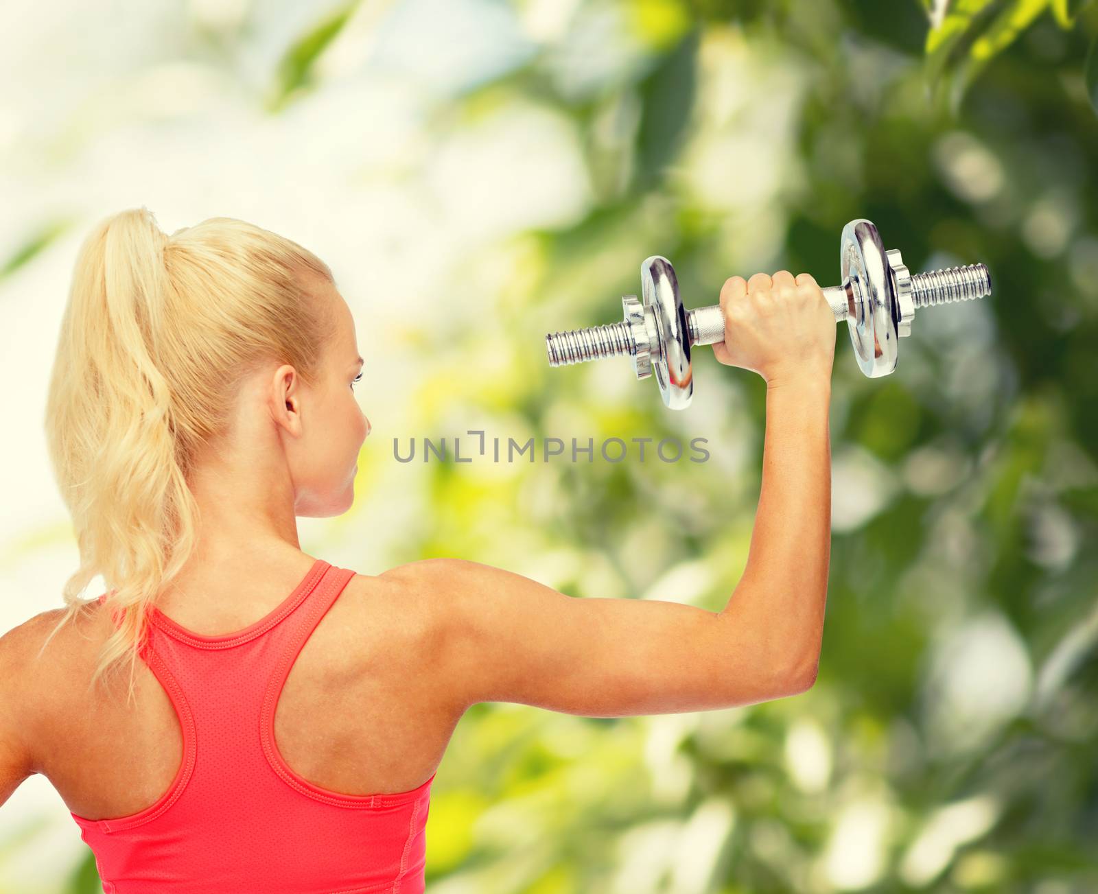 sporty woman with heavy steel dumbbell from back by dolgachov