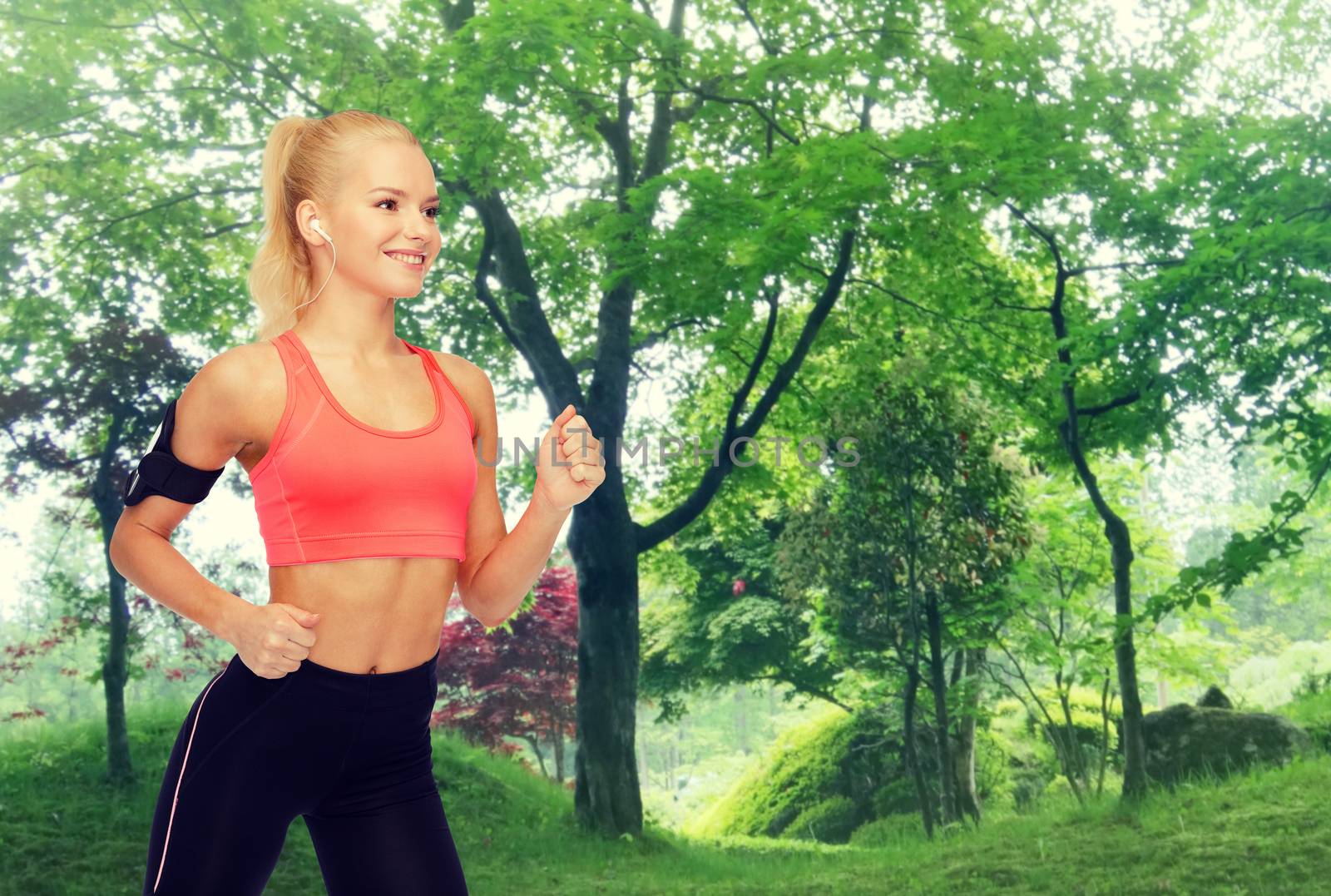 sporty woman running with smartphone and earphones by dolgachov