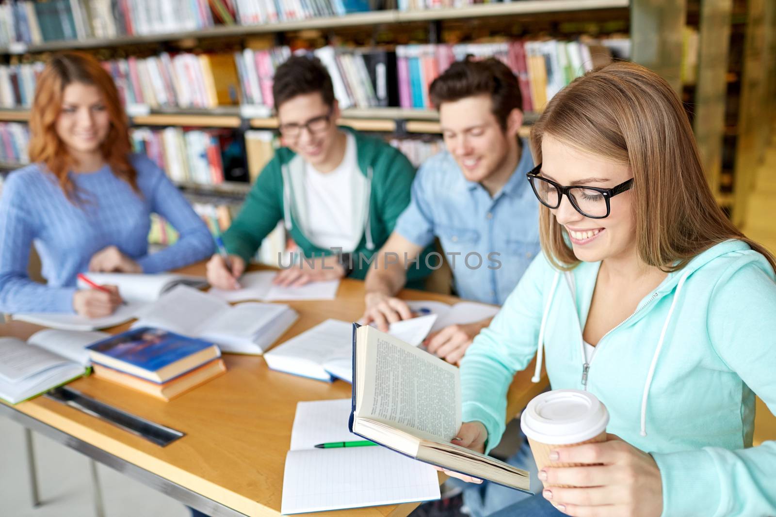 students reading and drinking coffee in library by dolgachov