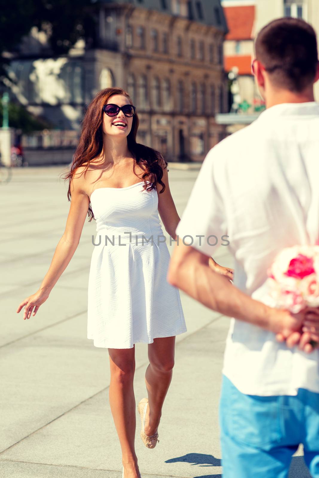 love, wedding, summer, dating and people concept - smiling couple wearing sunglasses with bunch of flowers looking at each other in city