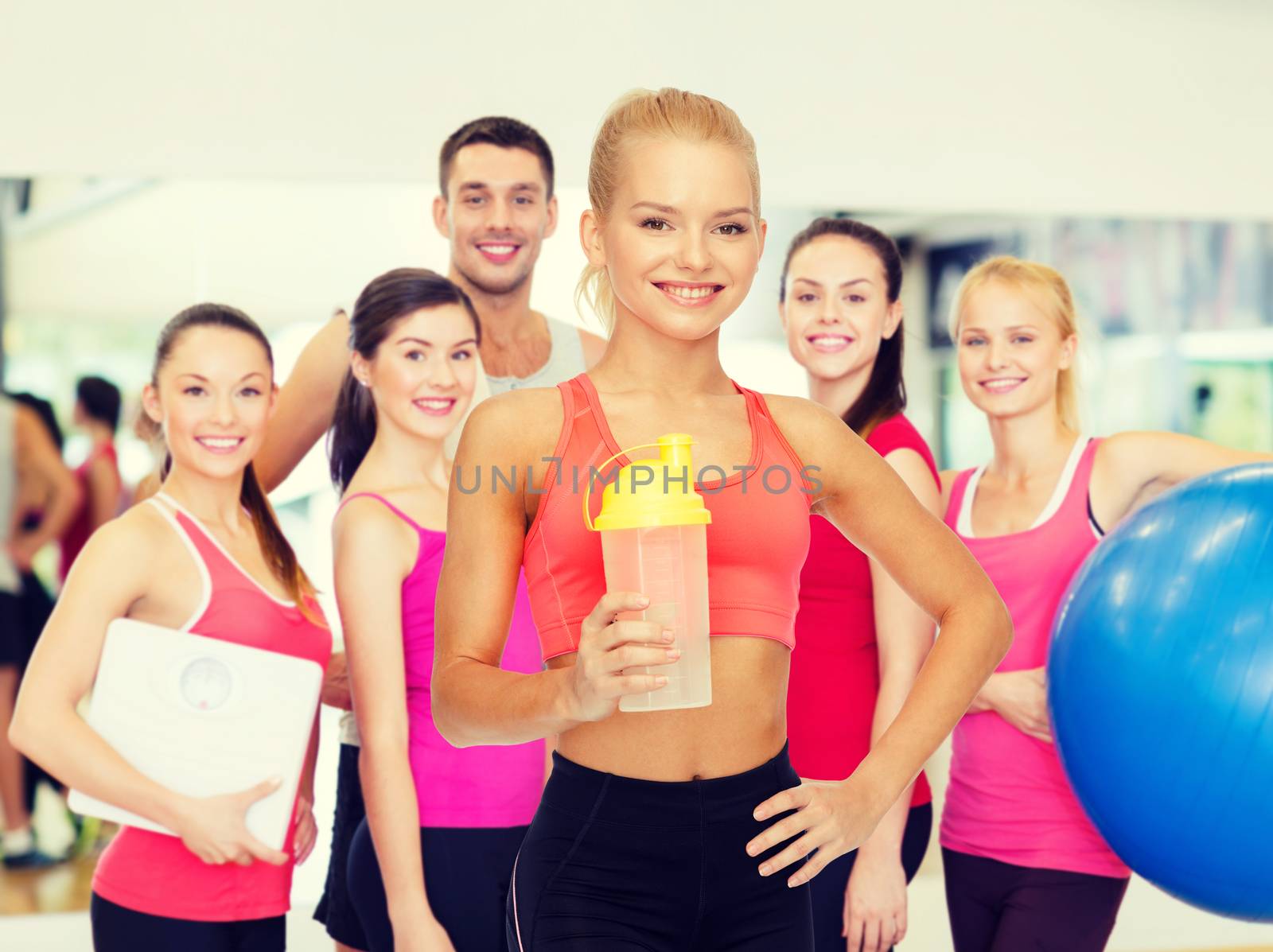 sport, fitness and diet concept - smiling sporty woman with protein shake bottle