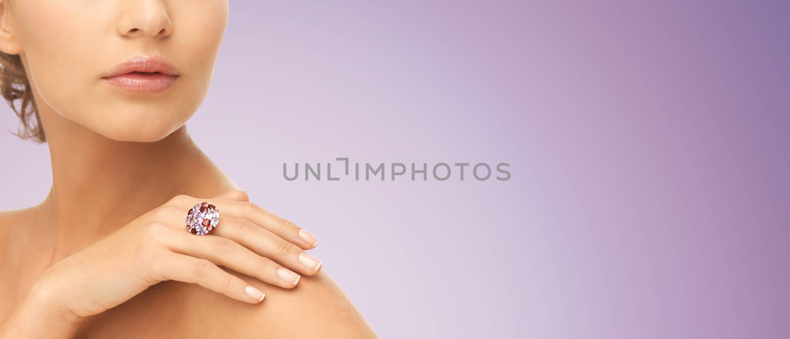 beauty, jewelry, people and accessories concept - close up of woman with cocktail ring on hand over violet background