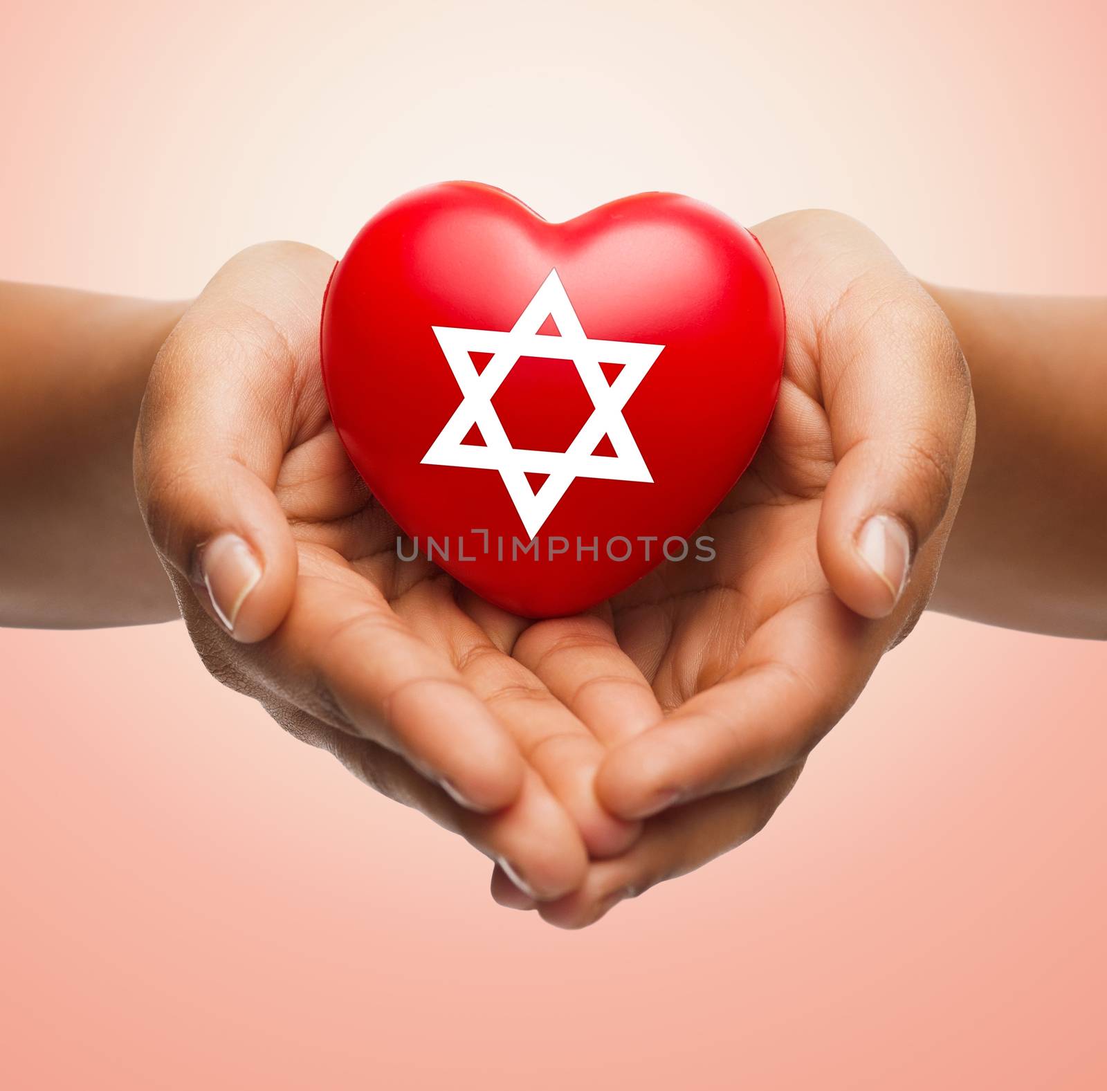 religion, christianity, jewish community and charity concept - close up of female hands holding red heart with star of david symbol over beige background