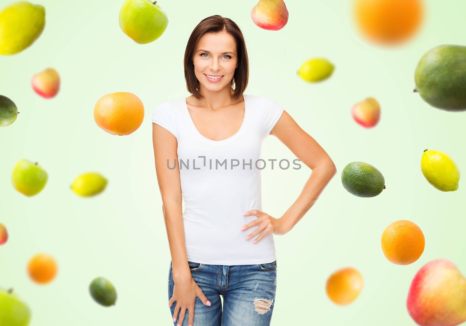people, advertisement, diet, food and healthy eating concept - happy woman in blank white t-shirt over fruits on green background