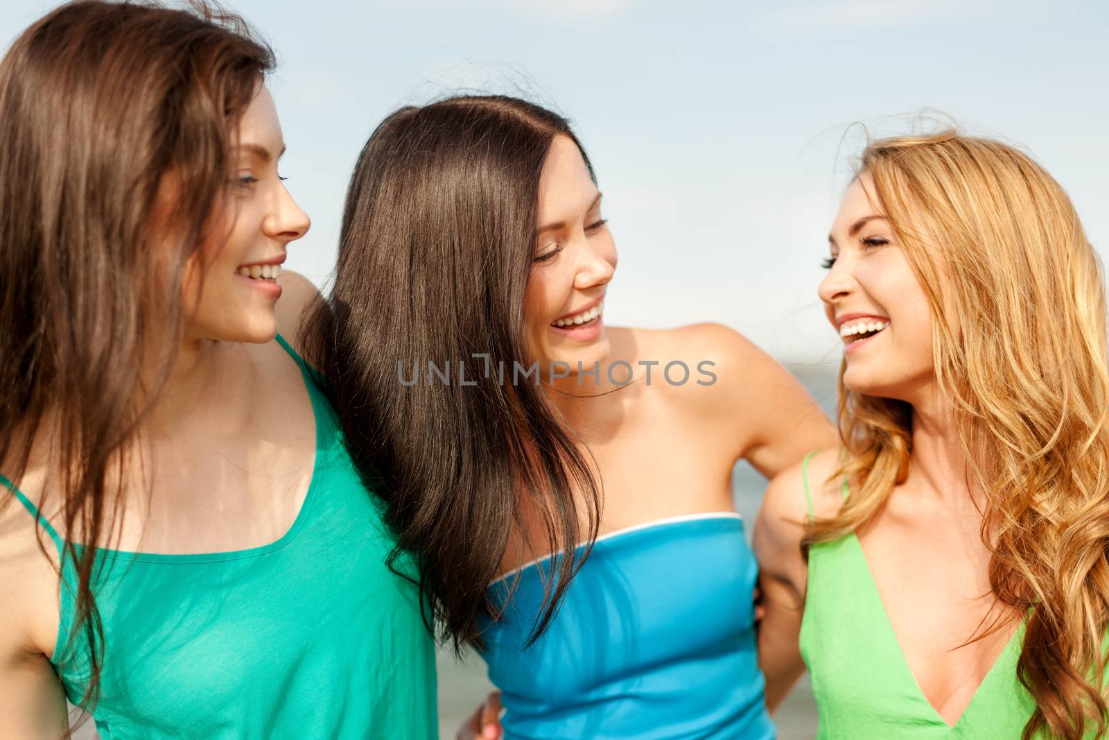 summer holidays and vacation concept - smiling girls walking on the beach