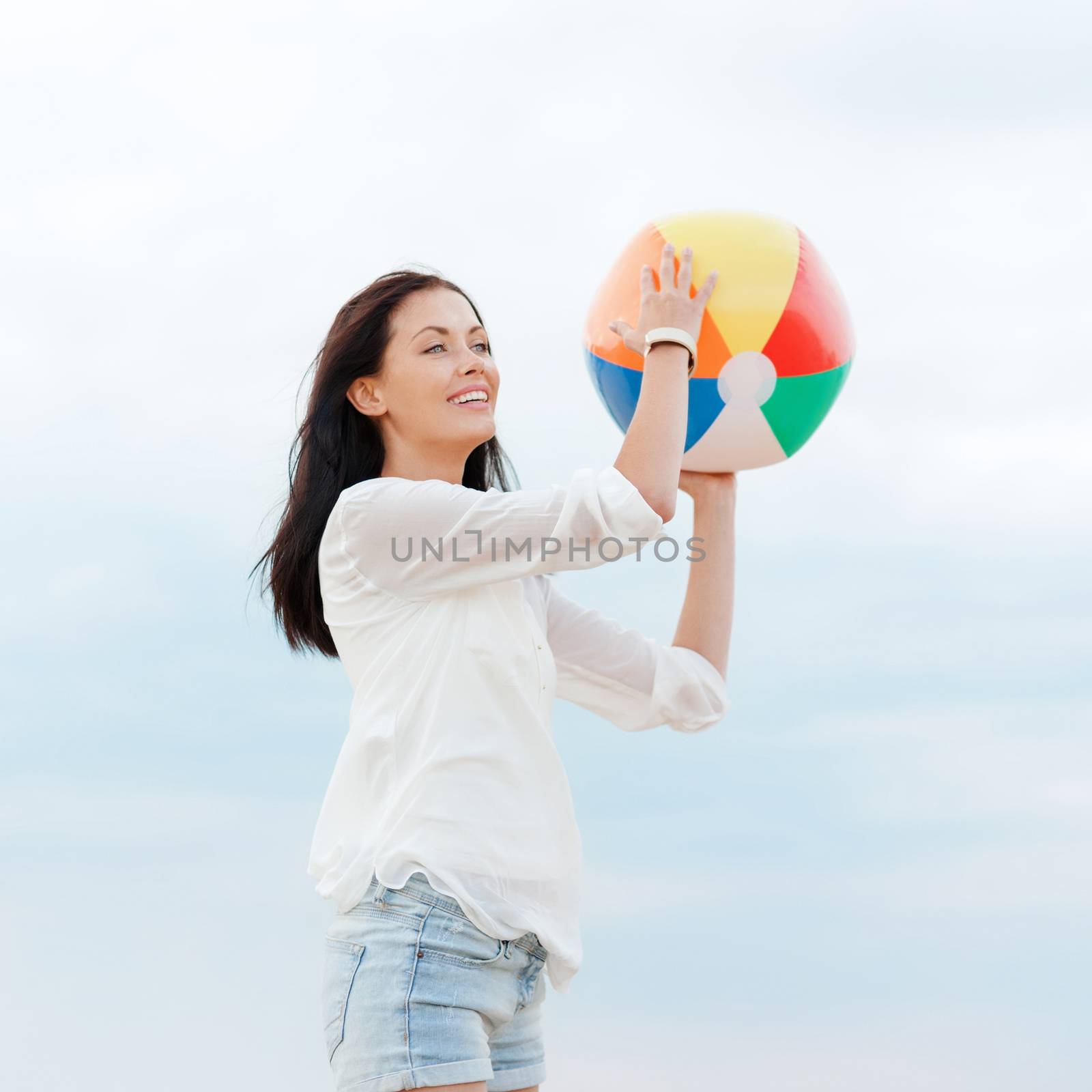 summer holidays, vacation and beach activities concept - girl with ball on the beach