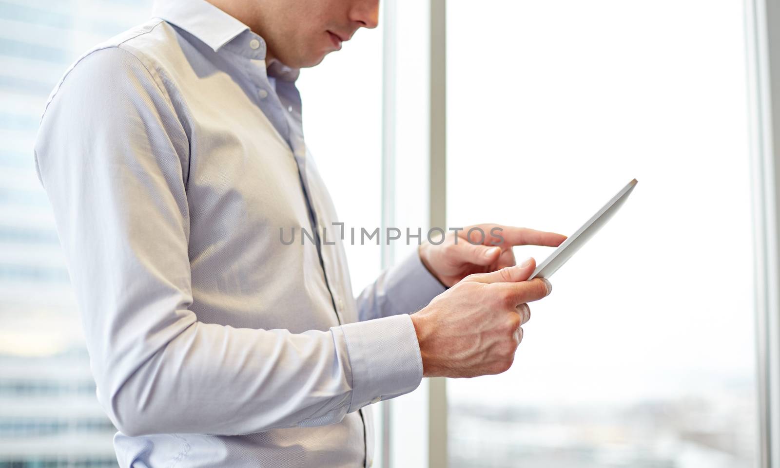 businessman with tablet pc in office by dolgachov
