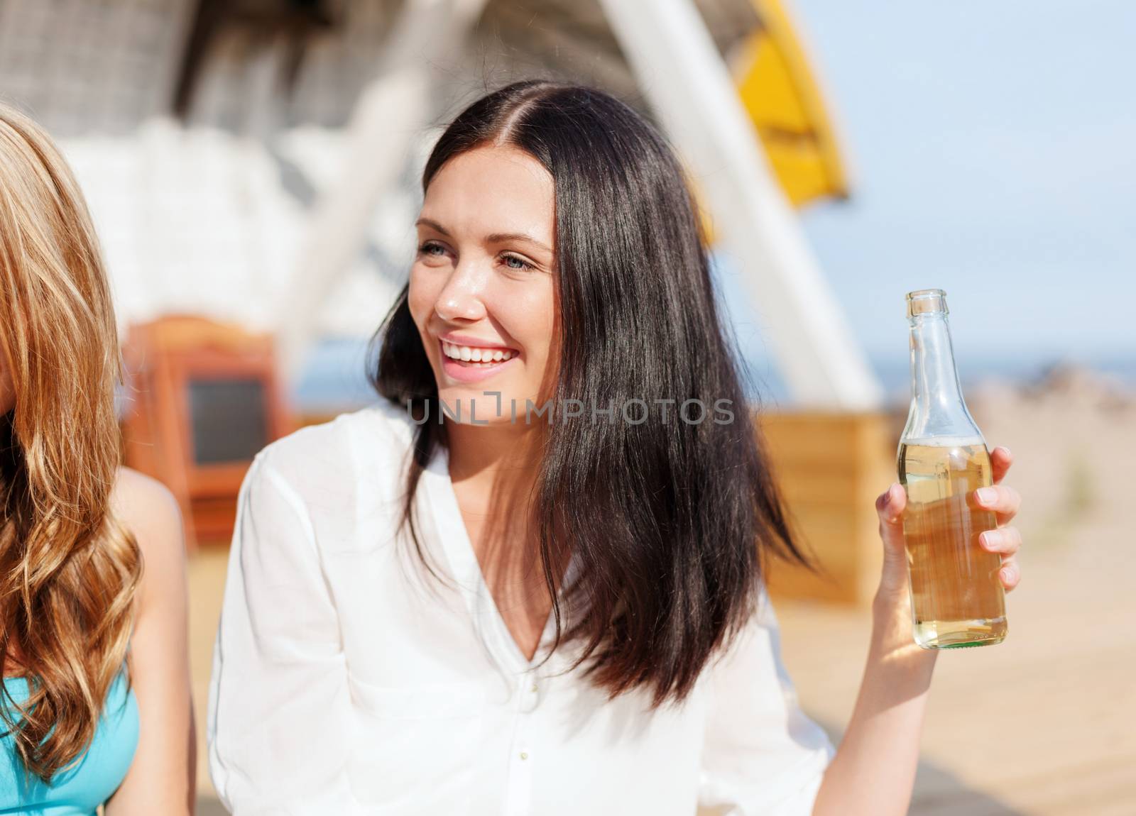 girl with drink and friends on the beach by dolgachov