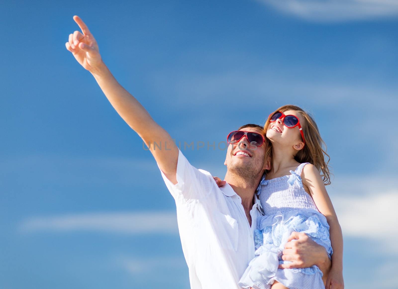 happy father and child in sunglasses over blue sky by dolgachov