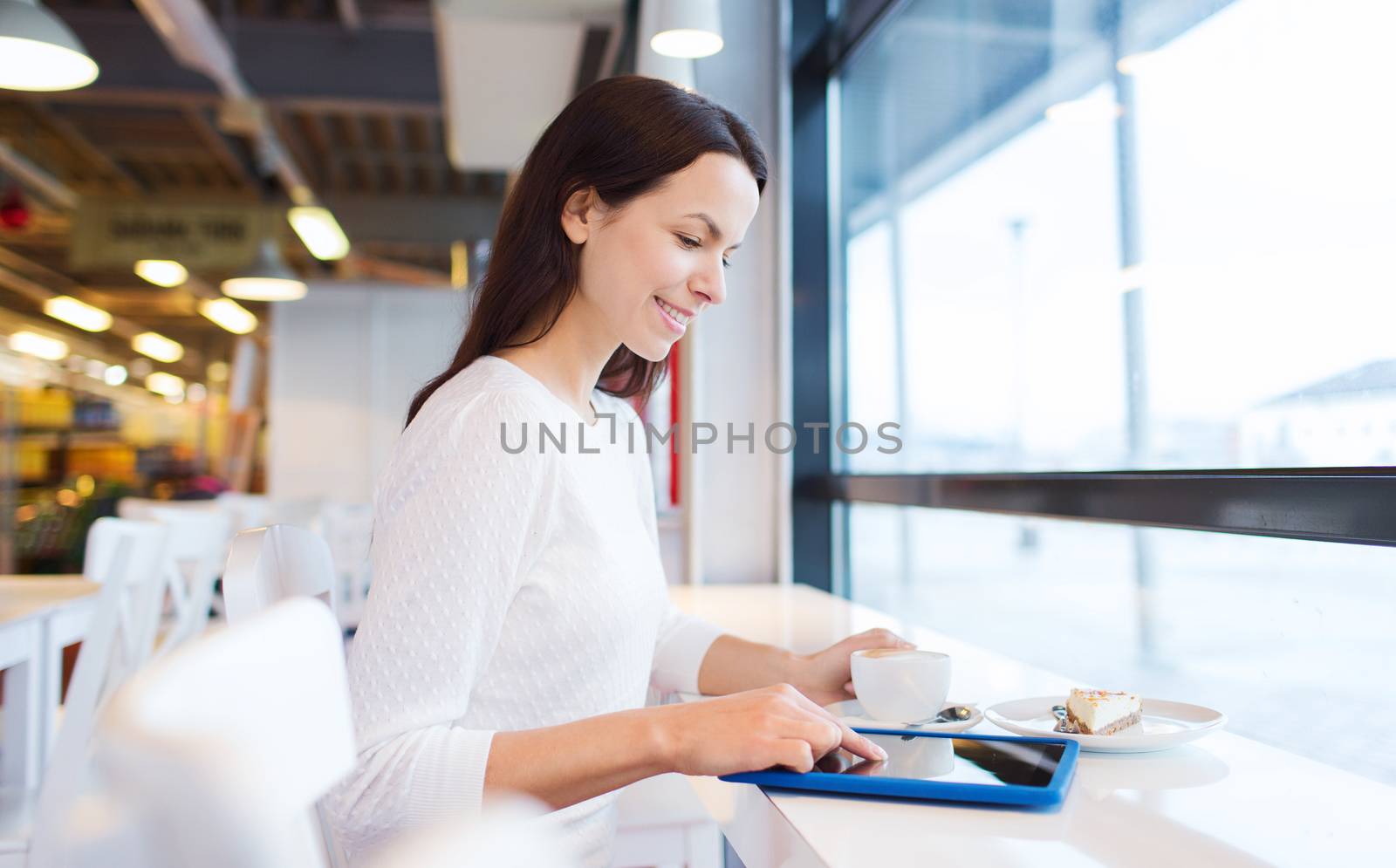 smiling woman with tablet pc and coffee at cafe by dolgachov