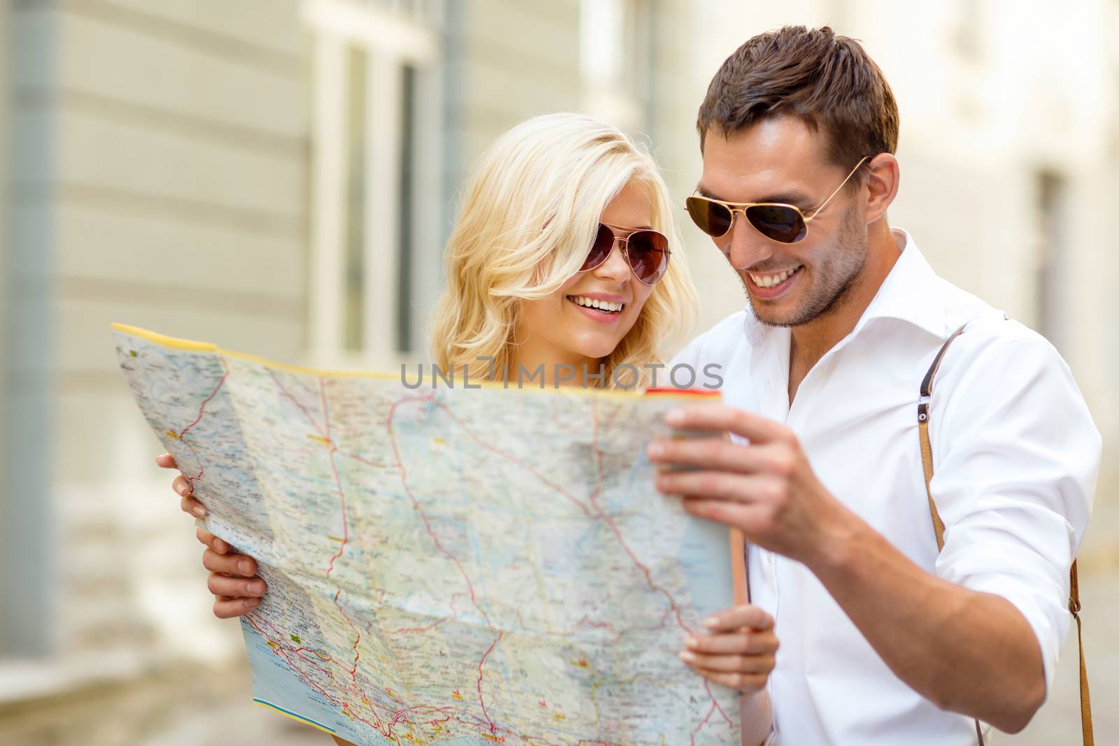 summer holidays, dating and tourism concept - smiling couple in sunglasses with map in the city