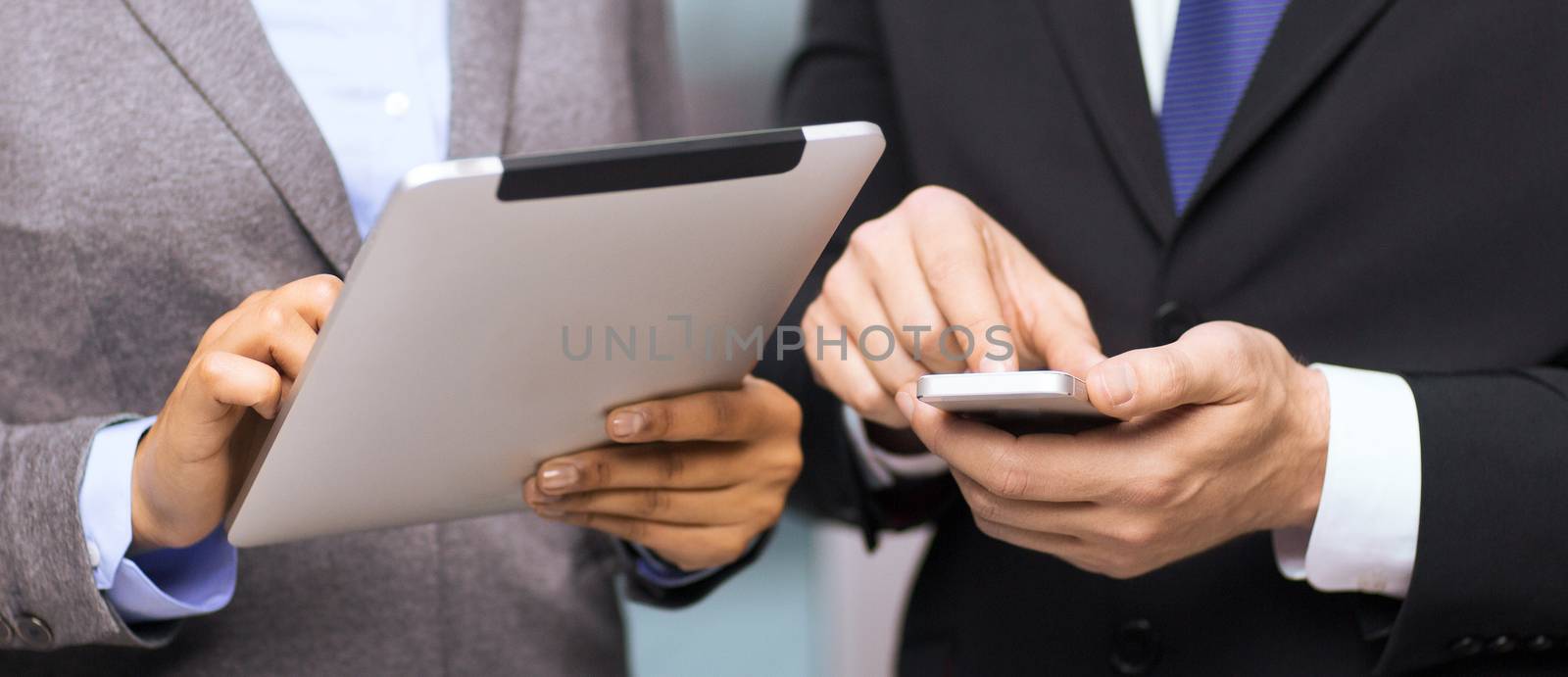 business, technology, internet and office concept - businessman and businesswoman with smartphone and tablet pc computer in office