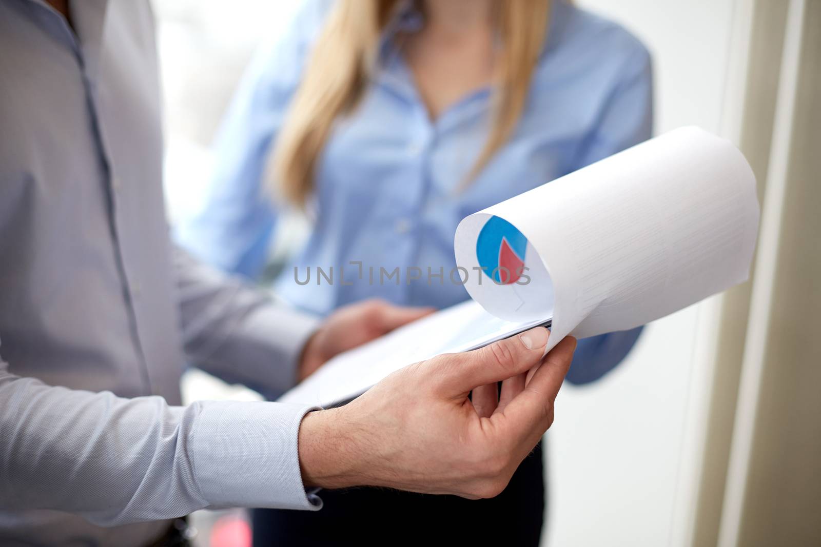 close up of business team looking at clipboard by dolgachov