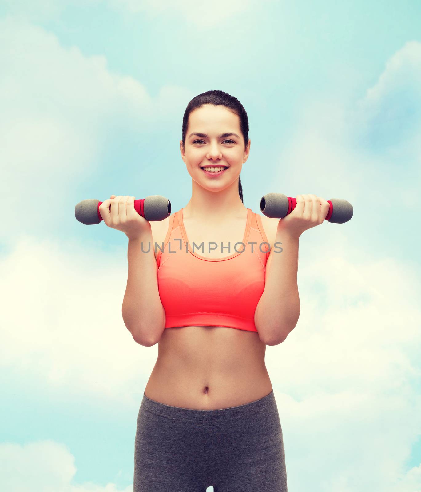 sport, exercising and healthcare concept - young sporty woman with light dumbbells