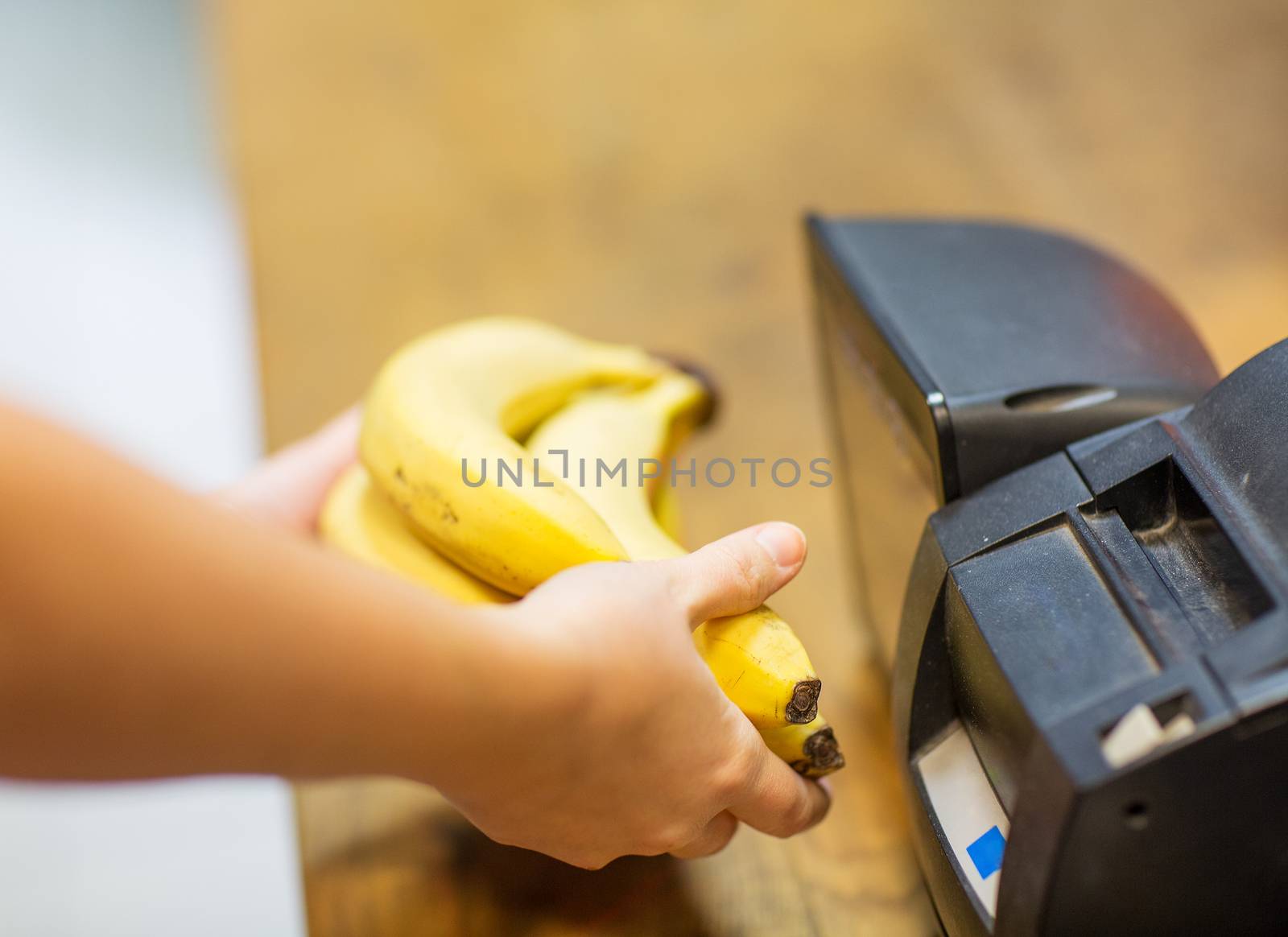 sale, shopping, payment, consumerism and people concept - close up of hands buying or scanning bananas at checkout in food market or mall