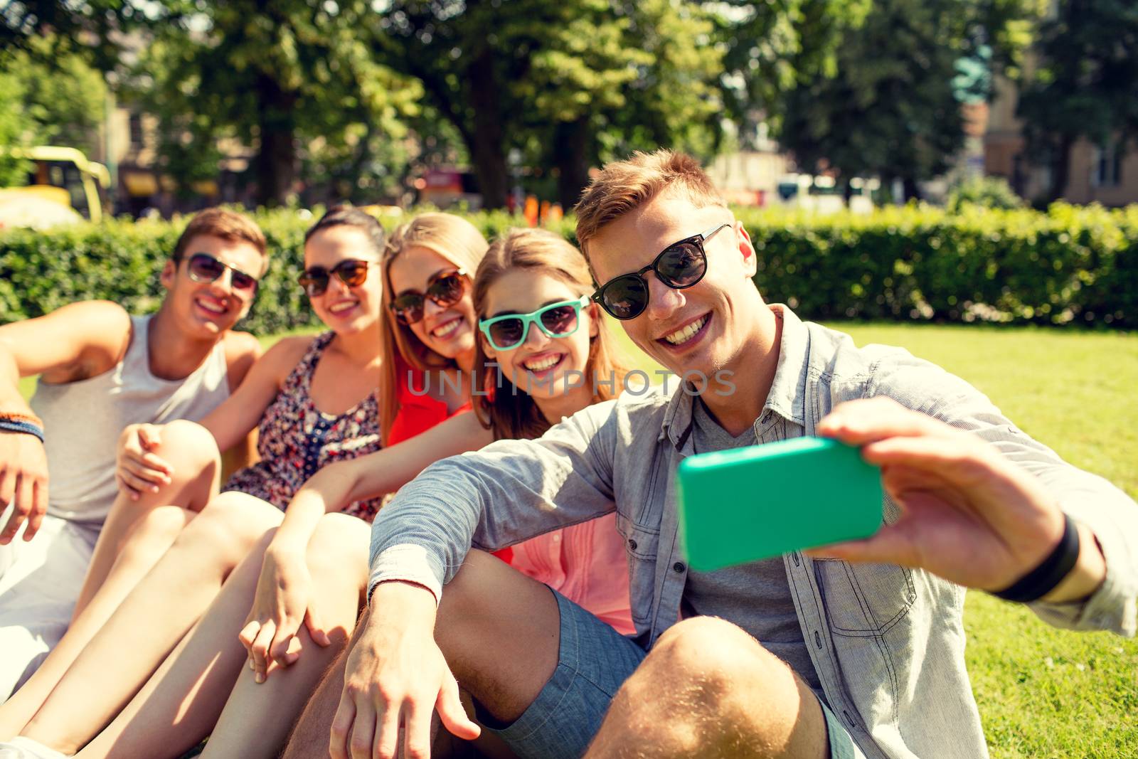 smiling friends with smartphone making selfie by dolgachov