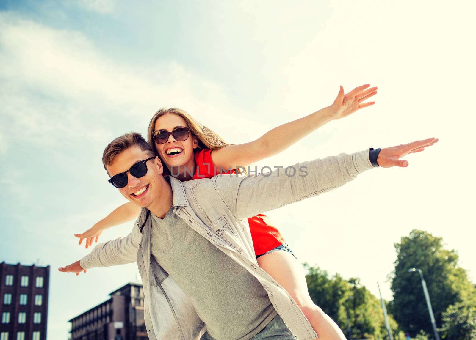 holidays, vacation, love and friendship concept - smiling couple having fun in city