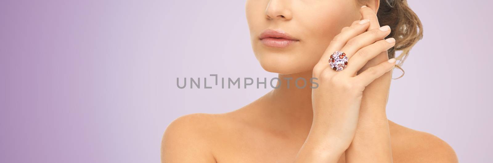 beauty, jewelry, people and accessories concept - close up of woman with cocktail ring on hand over violet background