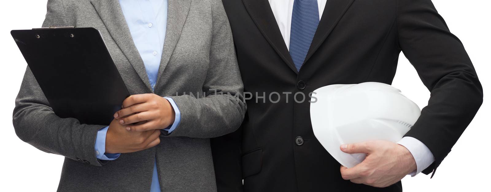 business, architecture and development concept - businesswoman and businessman with clipboard and white helmet