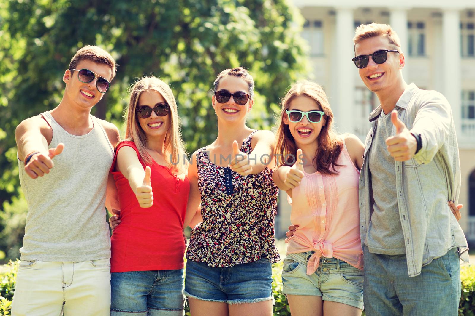 friendship, leisure, summer, gesture and people concept - group of smiling friends showing thumbs up outdoors