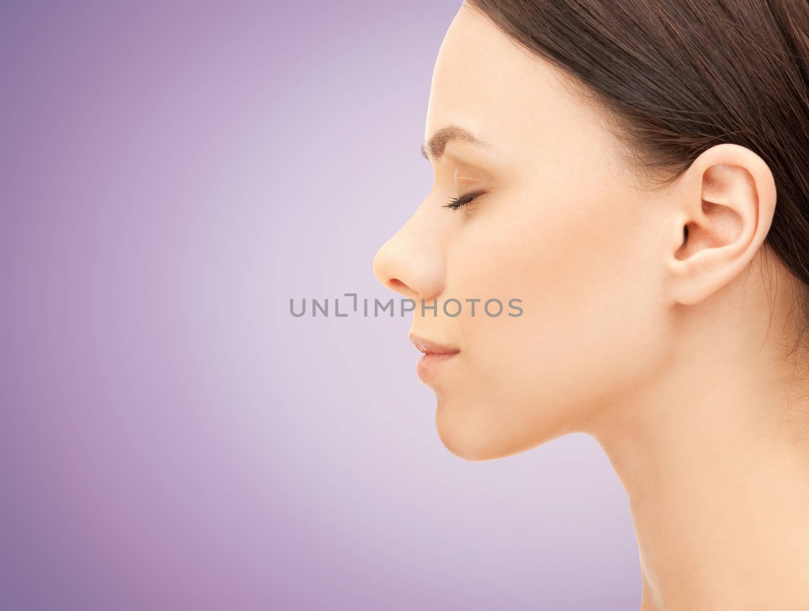 beautiful young woman face over violet background by dolgachov