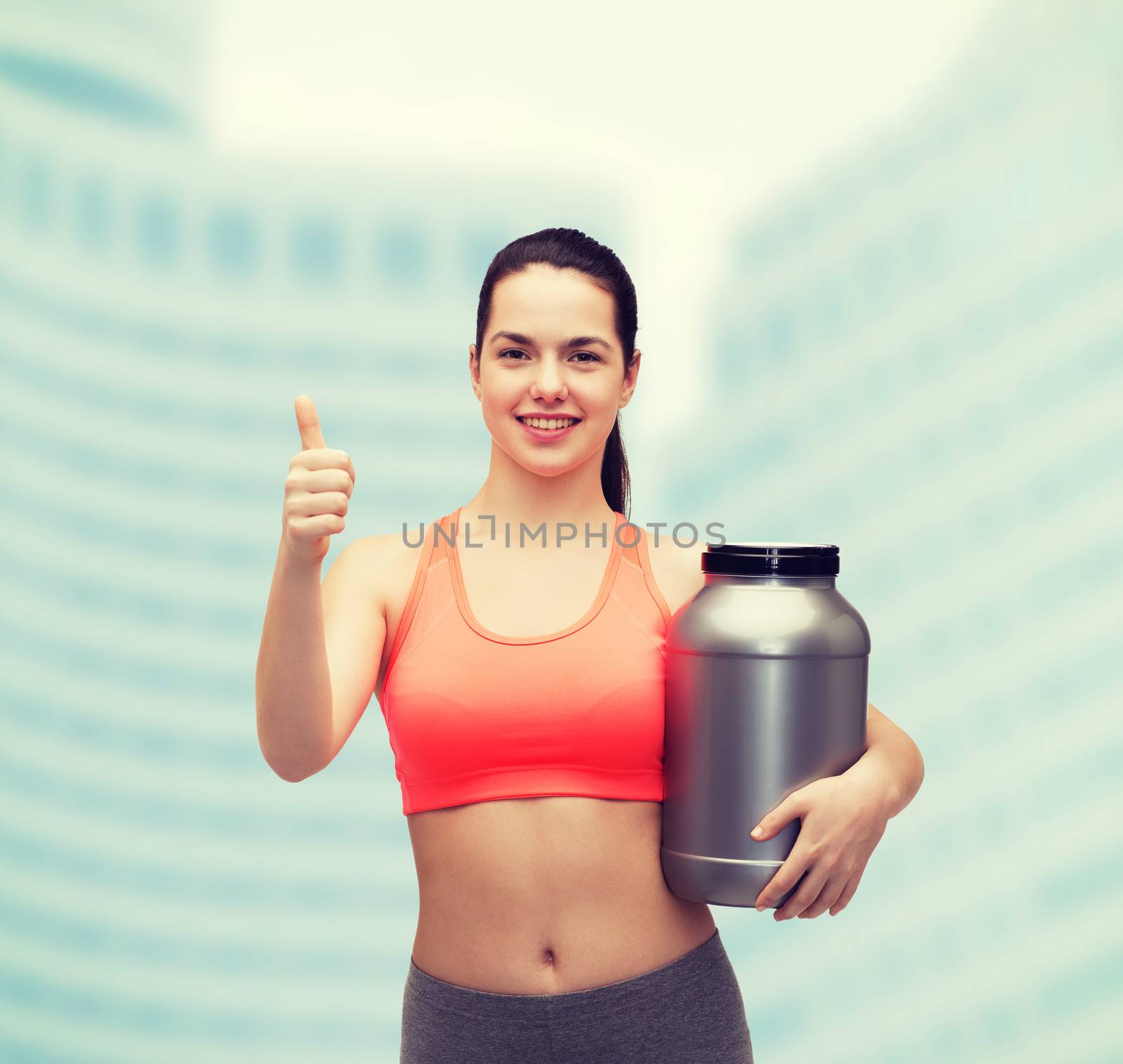 teenage girl with jar of protein showing thumbs up by dolgachov