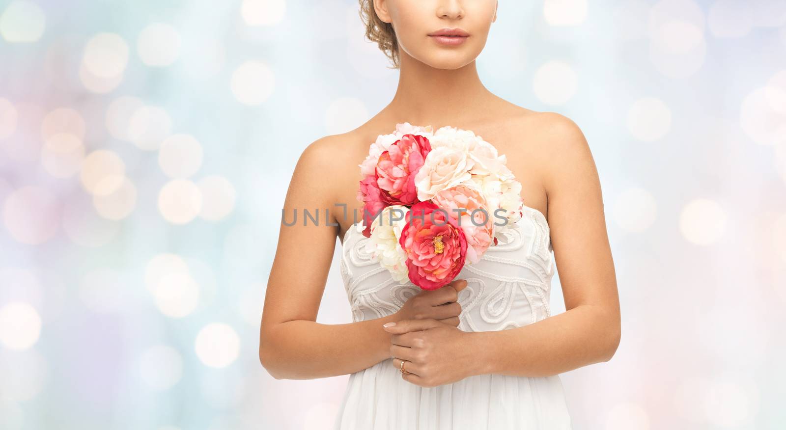 wedding, holidays, people and celebration concept- bride or woman with bouquet of flowers over blue holidays lights background