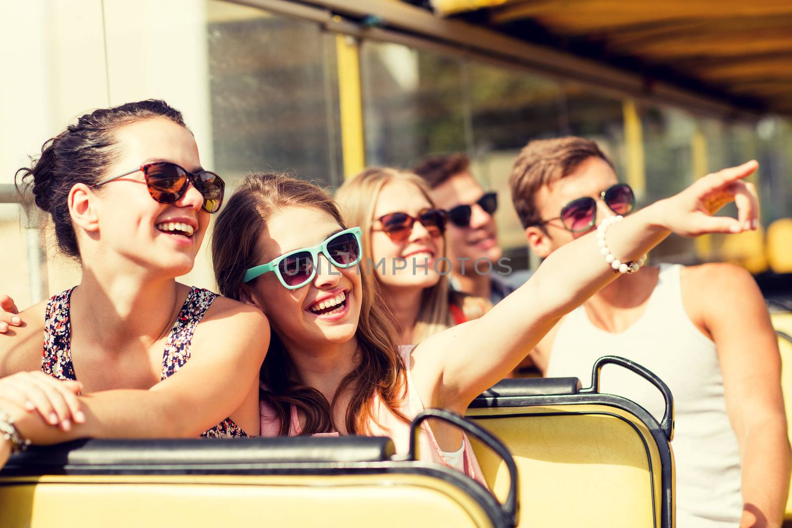 friendship, travel, vacation, summer and people concept - group of smiling friends traveling by tour bus