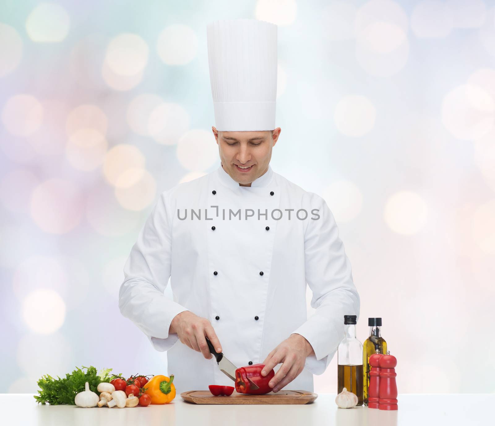 cooking, profession, vegetarian, food and people concept - happy male chef chopping pepper over blue lights background