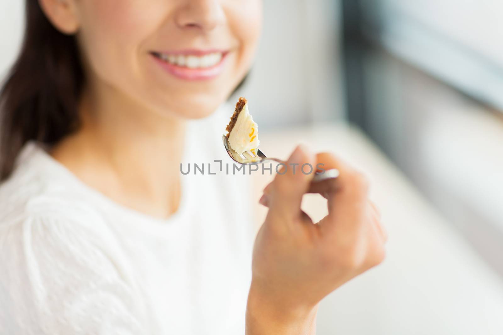 close up of woman eating cake at cafe or home by dolgachov