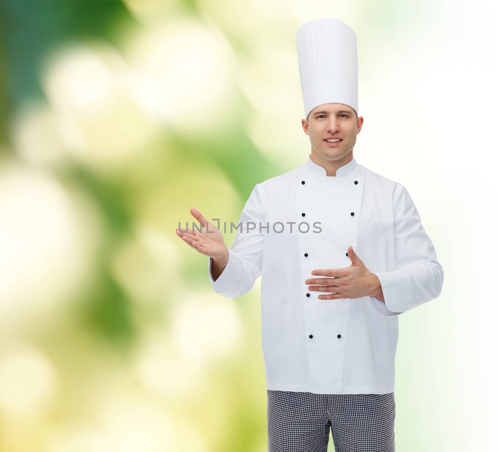 cooking, profession and people concept - happy male chef cook inviting over green background