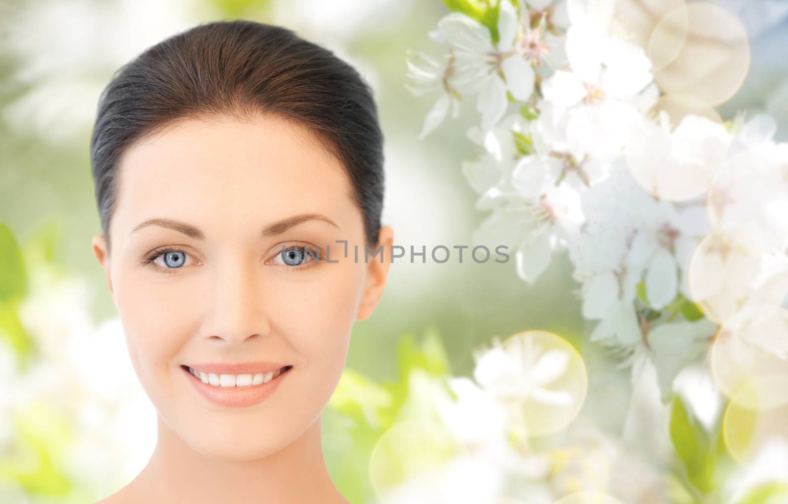 beauty, people and health concept - beautiful young woman face over green blooming garden background