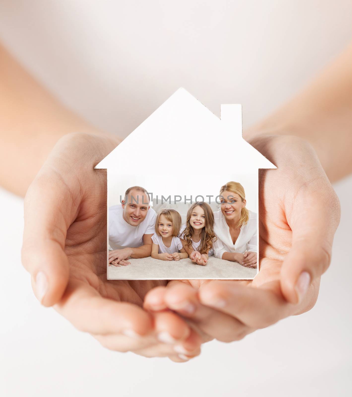 close up of hands holding house shape with family by dolgachov