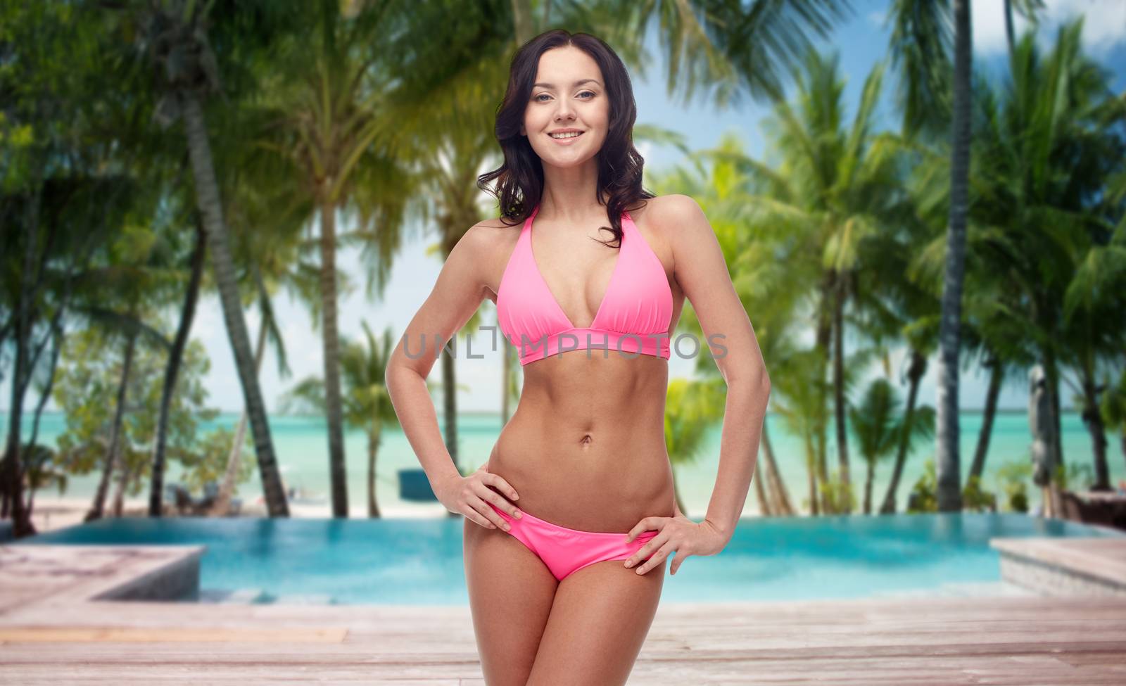 happy young woman in bikini over summer beach by dolgachov