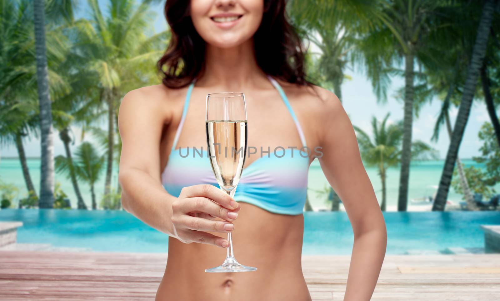 happy young woman in swimsuit drinking champagne by dolgachov