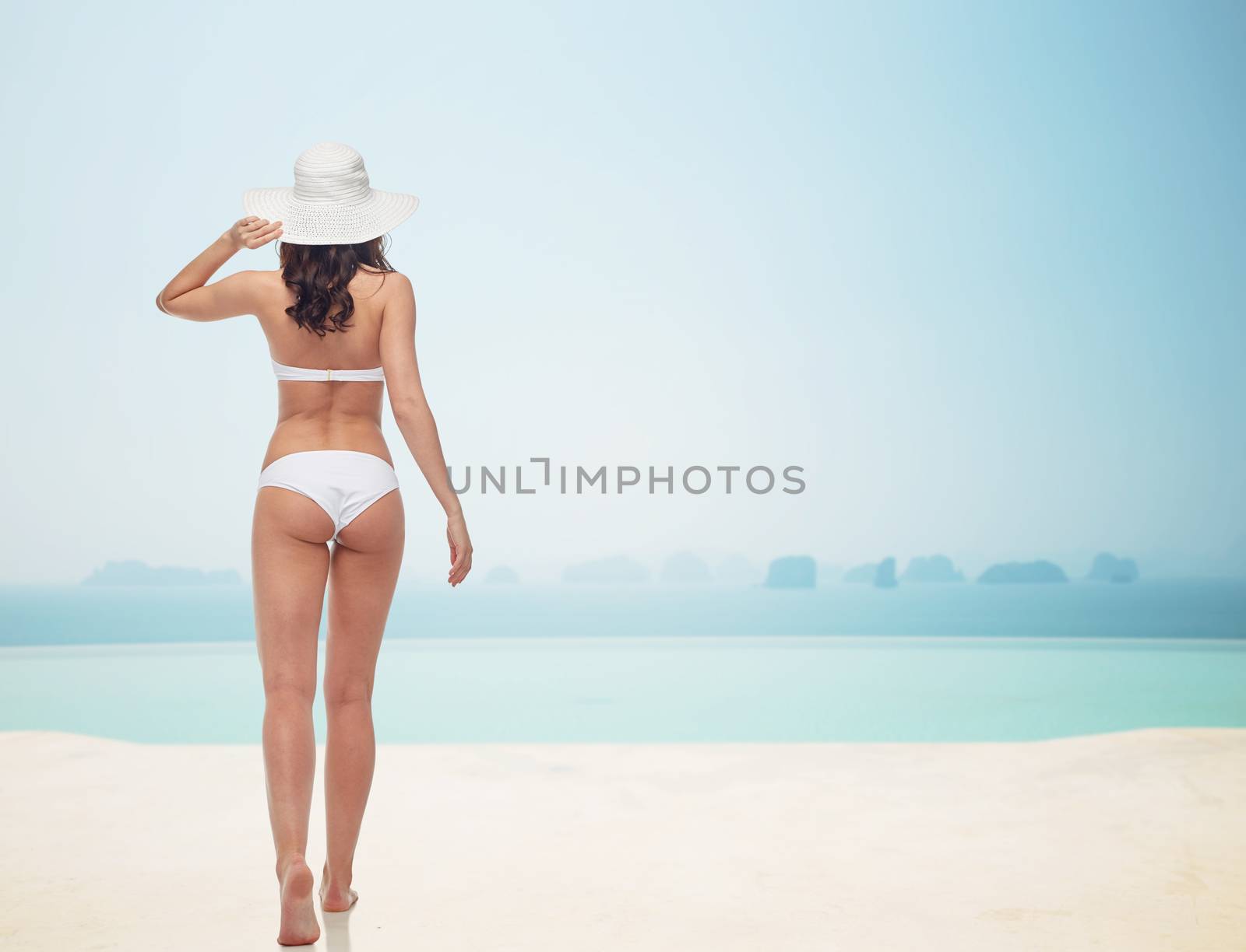 young woman in white bikini swimsuit from back by dolgachov