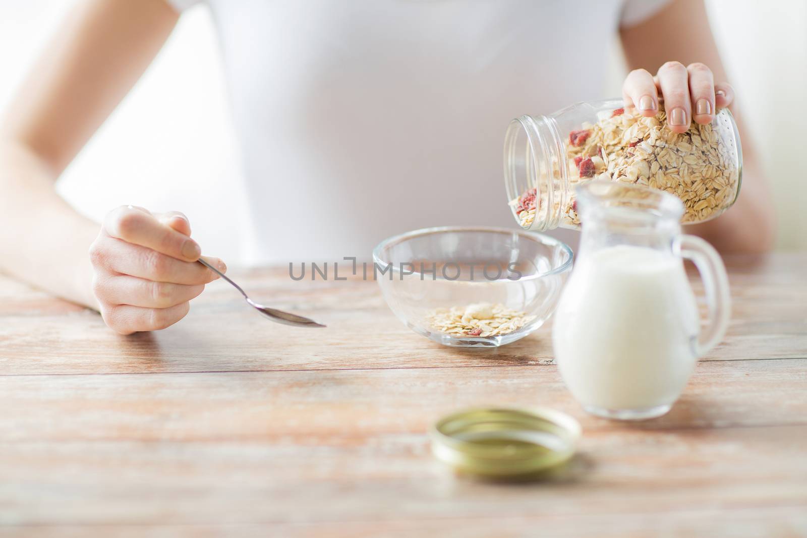close up of woman eating muesli for breakfast by dolgachov