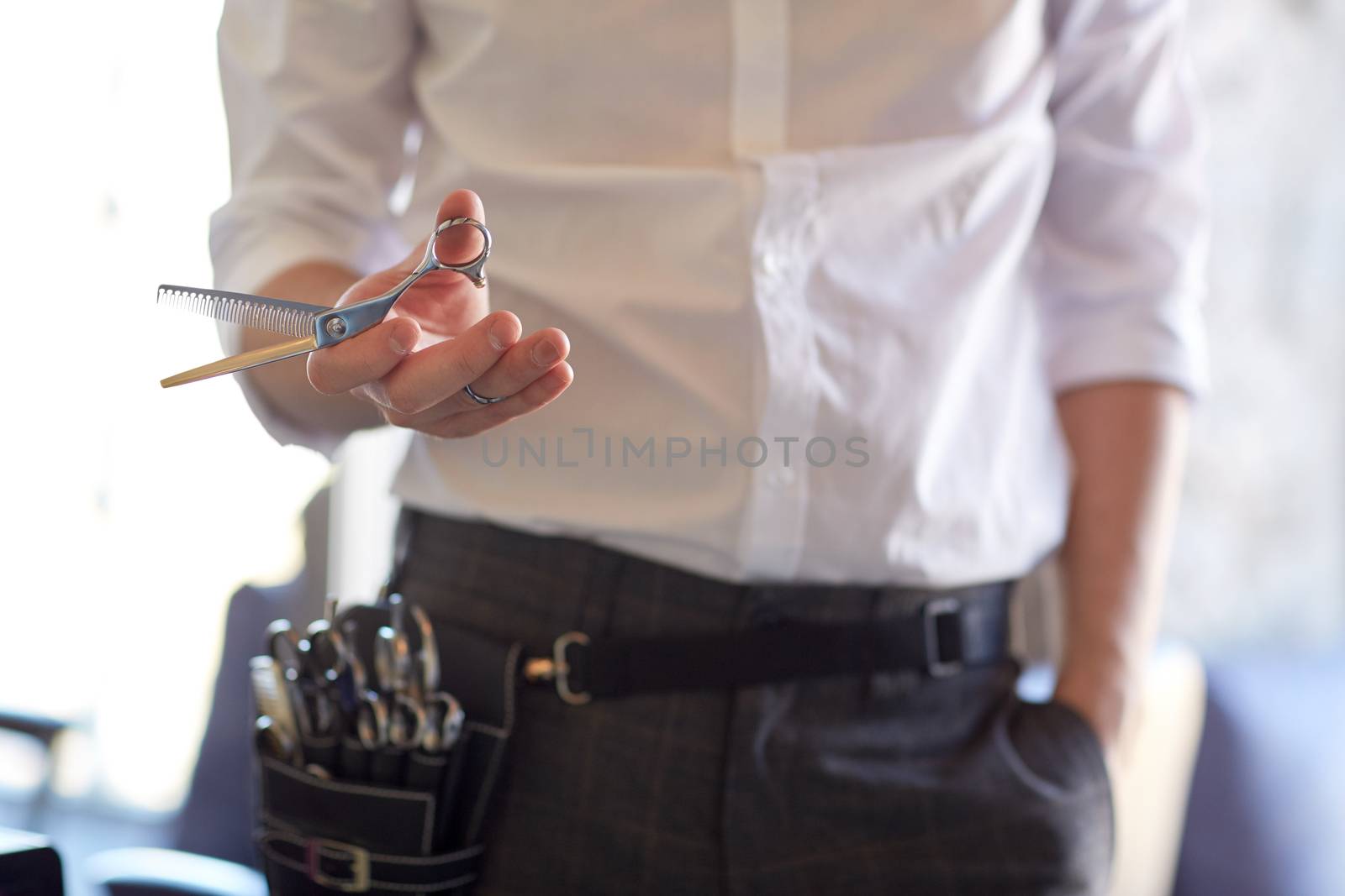 beauty, hairstyle and people concept -close up of male stylist with scissors at salon