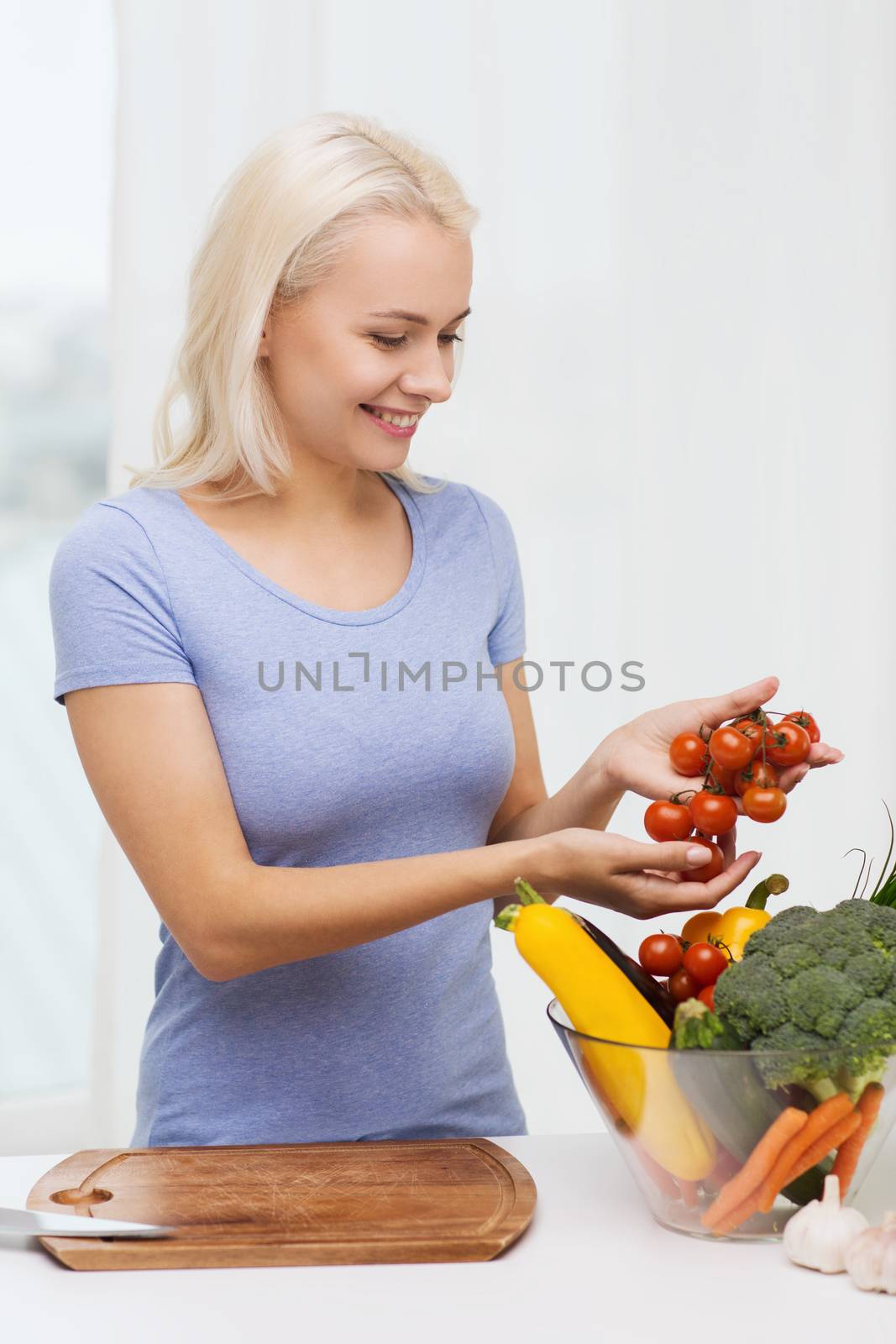 healthy eating, cooking, vegetarian food, dieting and people concept - smiling young woman with bowl of vegetables at home