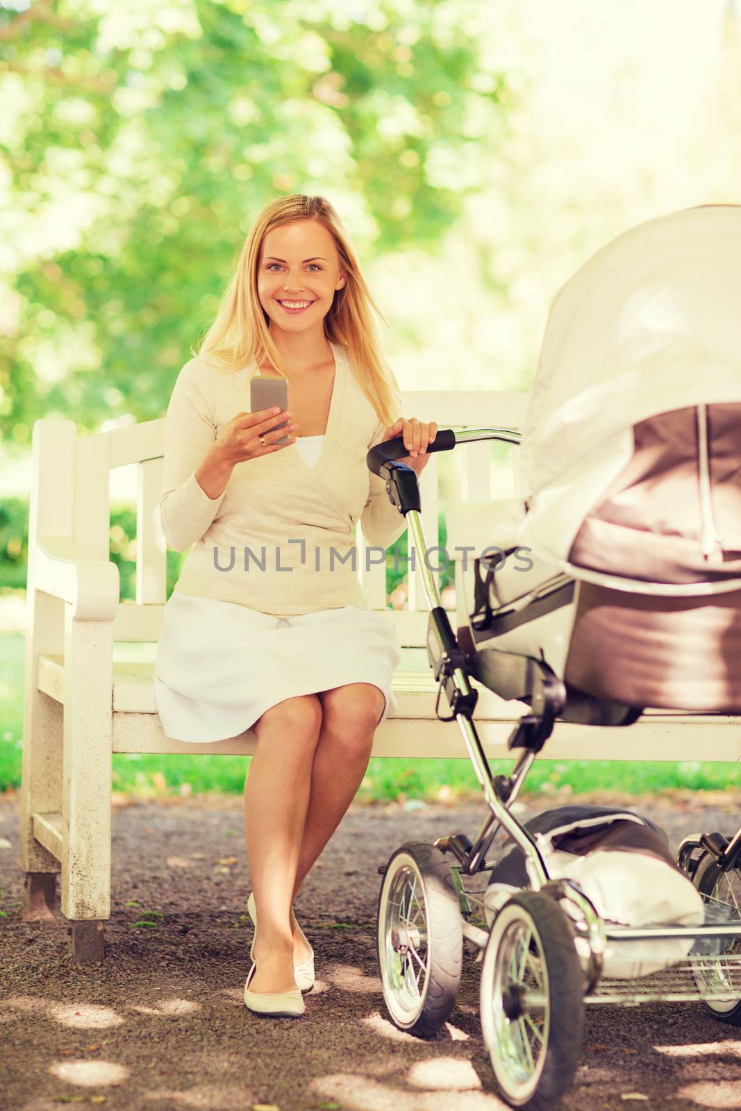 family, parenthood, technology and people concept - happy mother with with smartphone and baby stroller in park