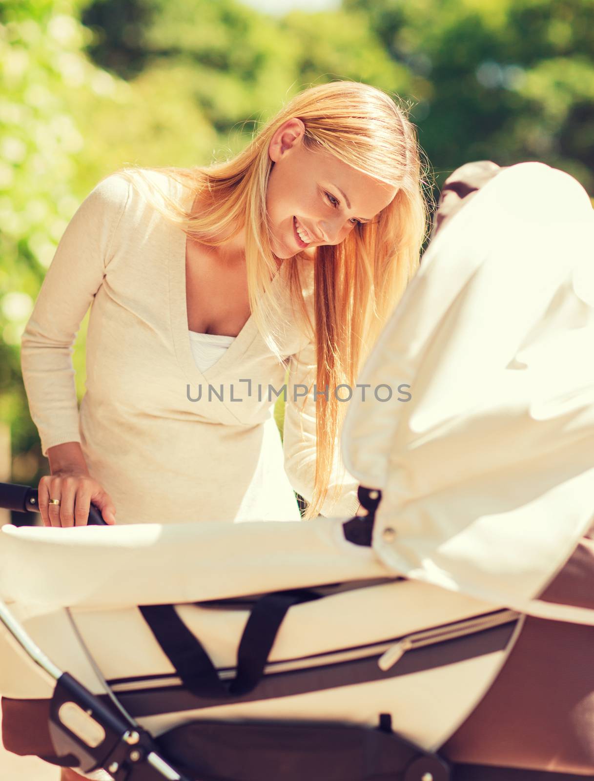 family, child and parenthood concept - happy mother with stroller in park