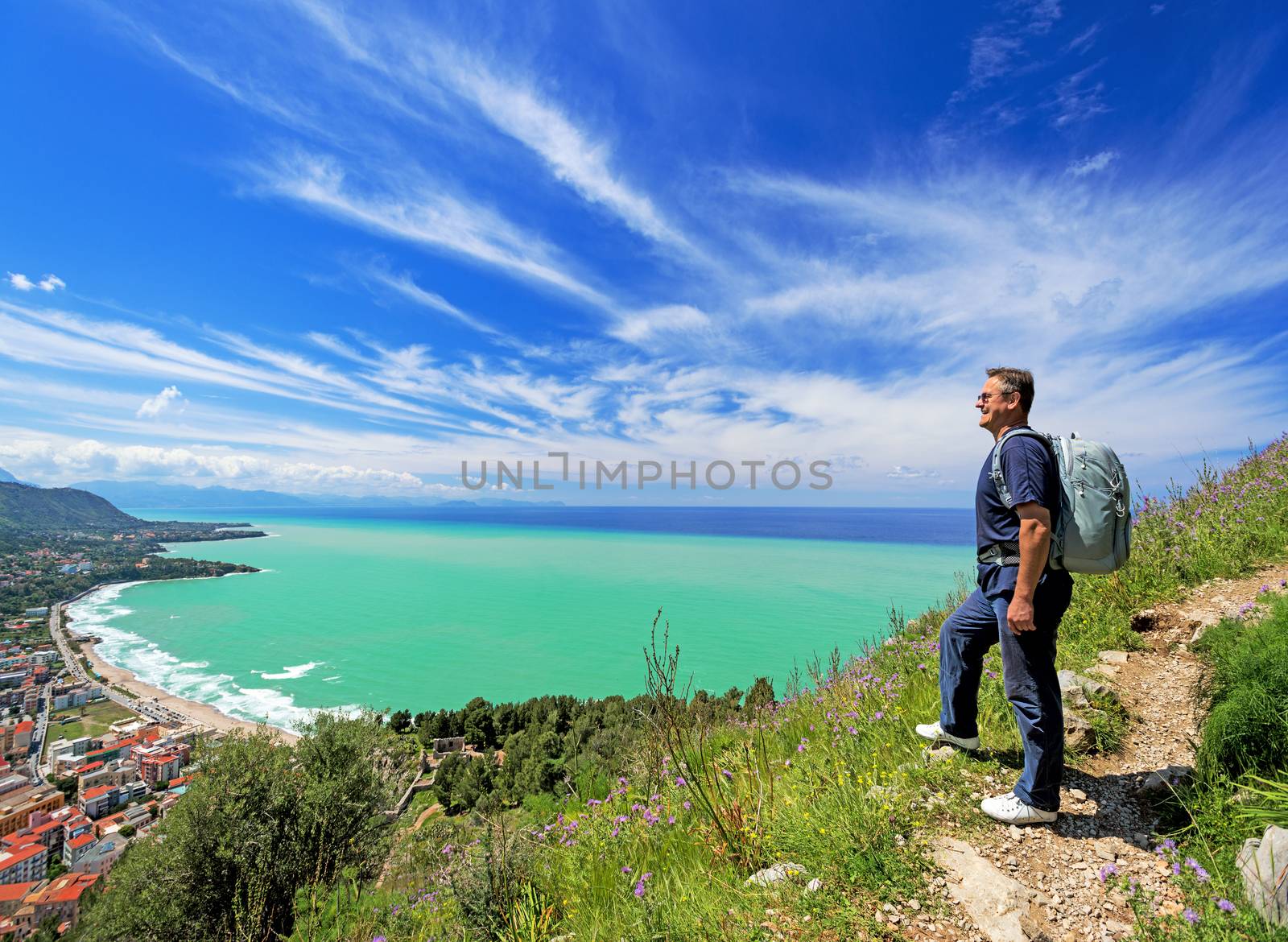 man with backpack looking at Cefalu, Sicily by Nanisimova