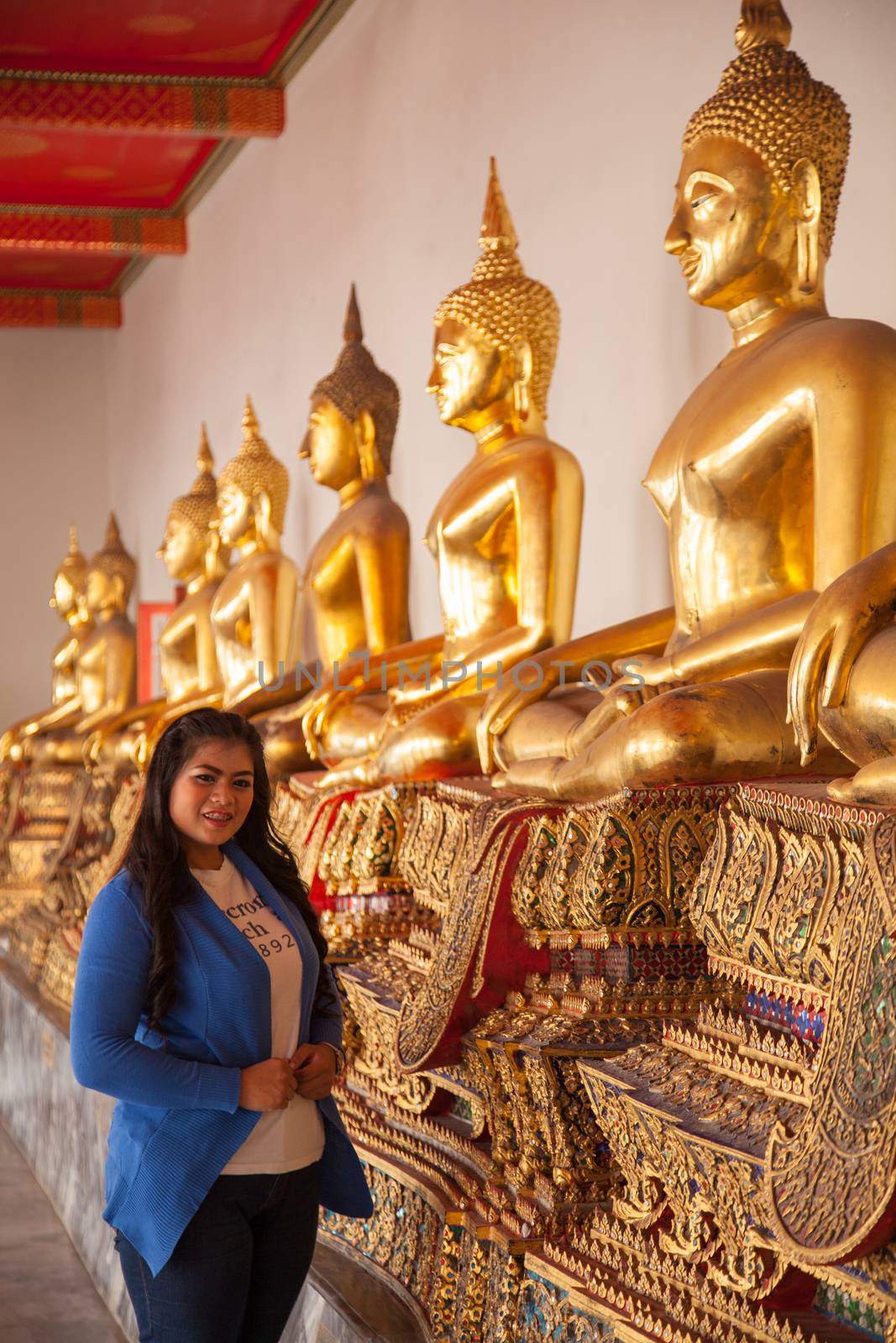 Long haired woman smiling. Visitors inside the temple Thailand