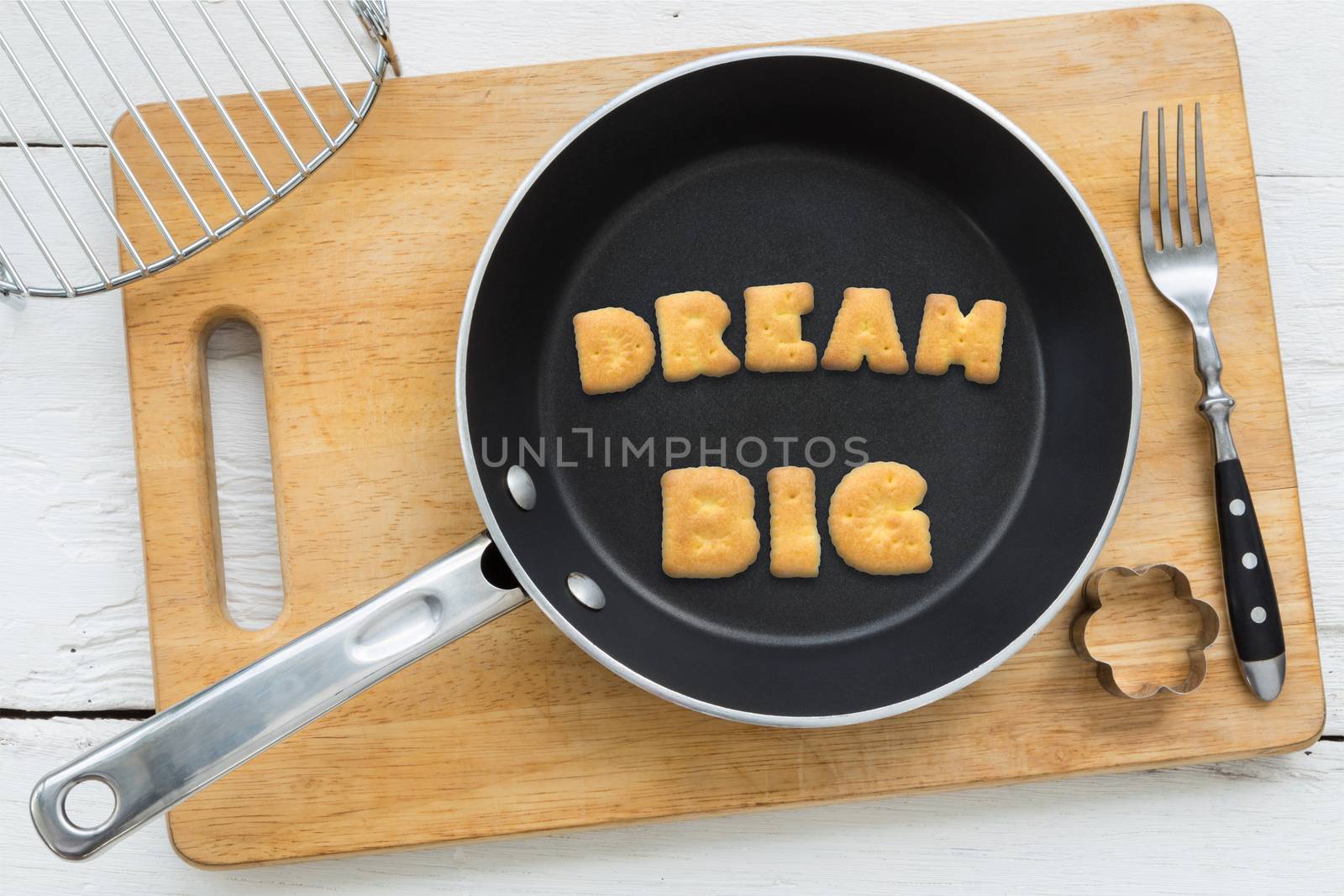 Alphabet crackers word DREAM BIG putting in pan by vinnstock