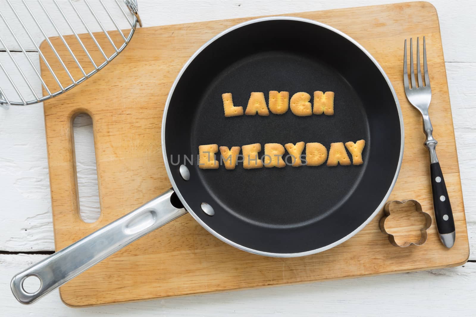 Letter cookies word LAUGH EVERYDAY and kitchen utensils by vinnstock