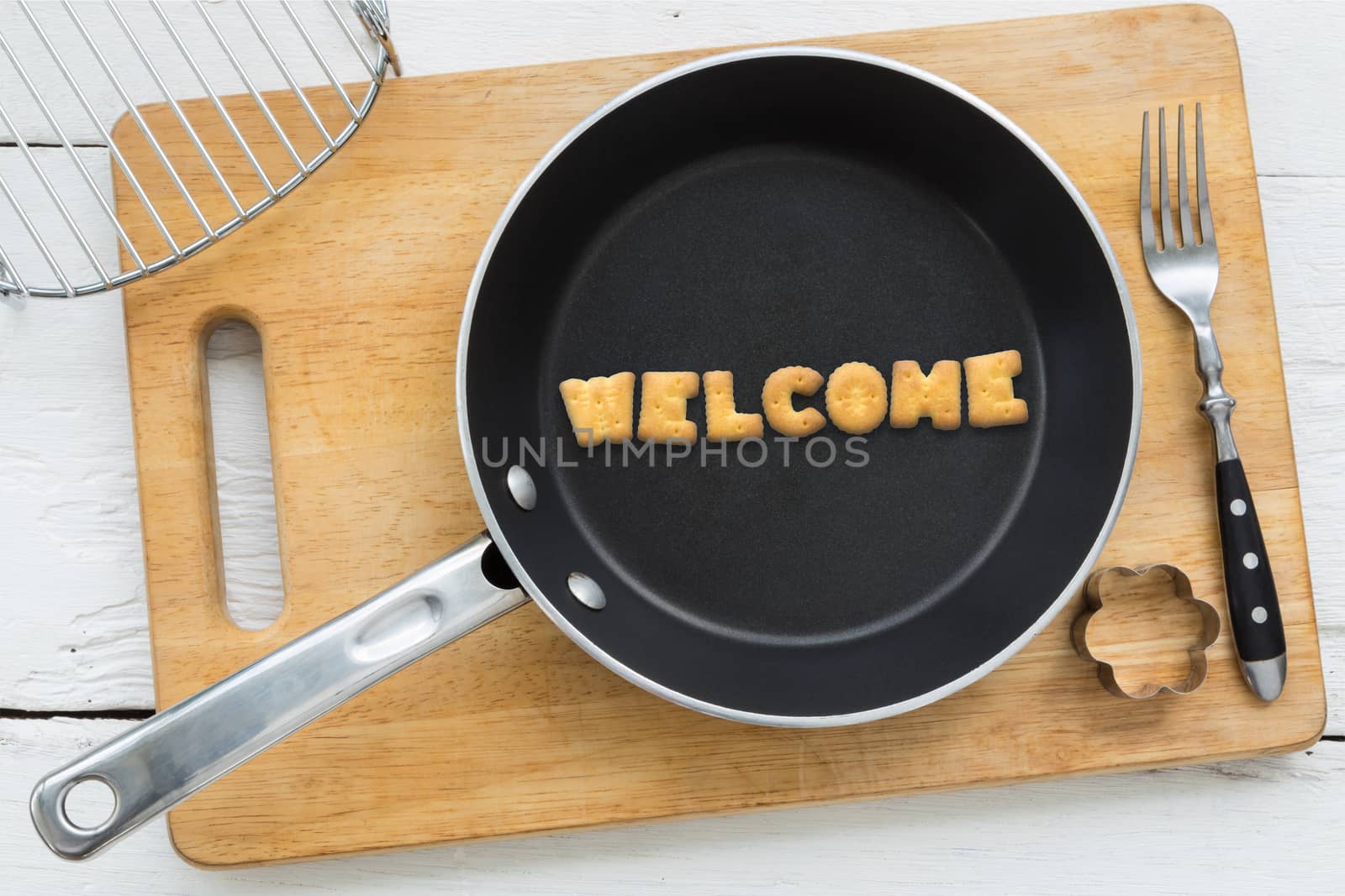 Cookie biscuits word WELCOME in frying pan by vinnstock
