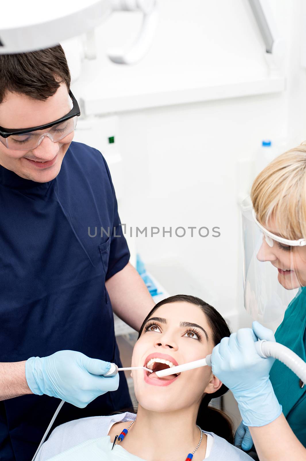 Dentist examining a woman teeth by stockyimages
