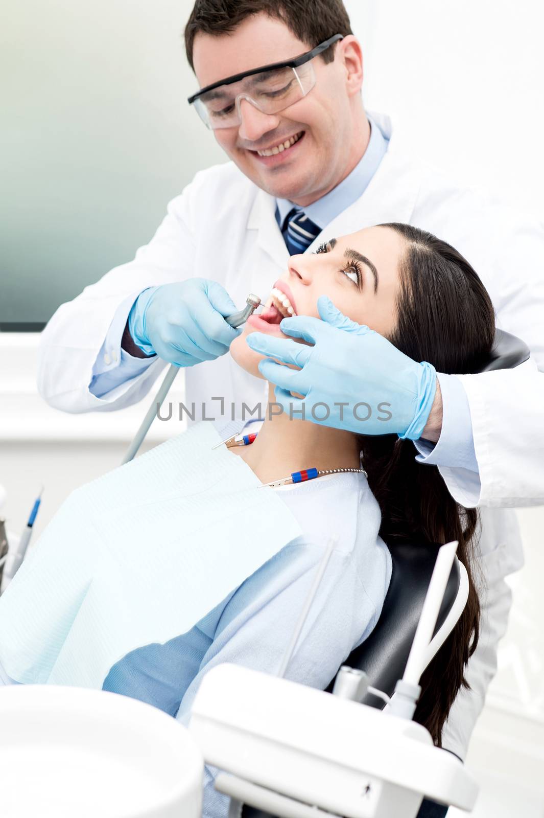 Male dentist treat female patient in dental office
